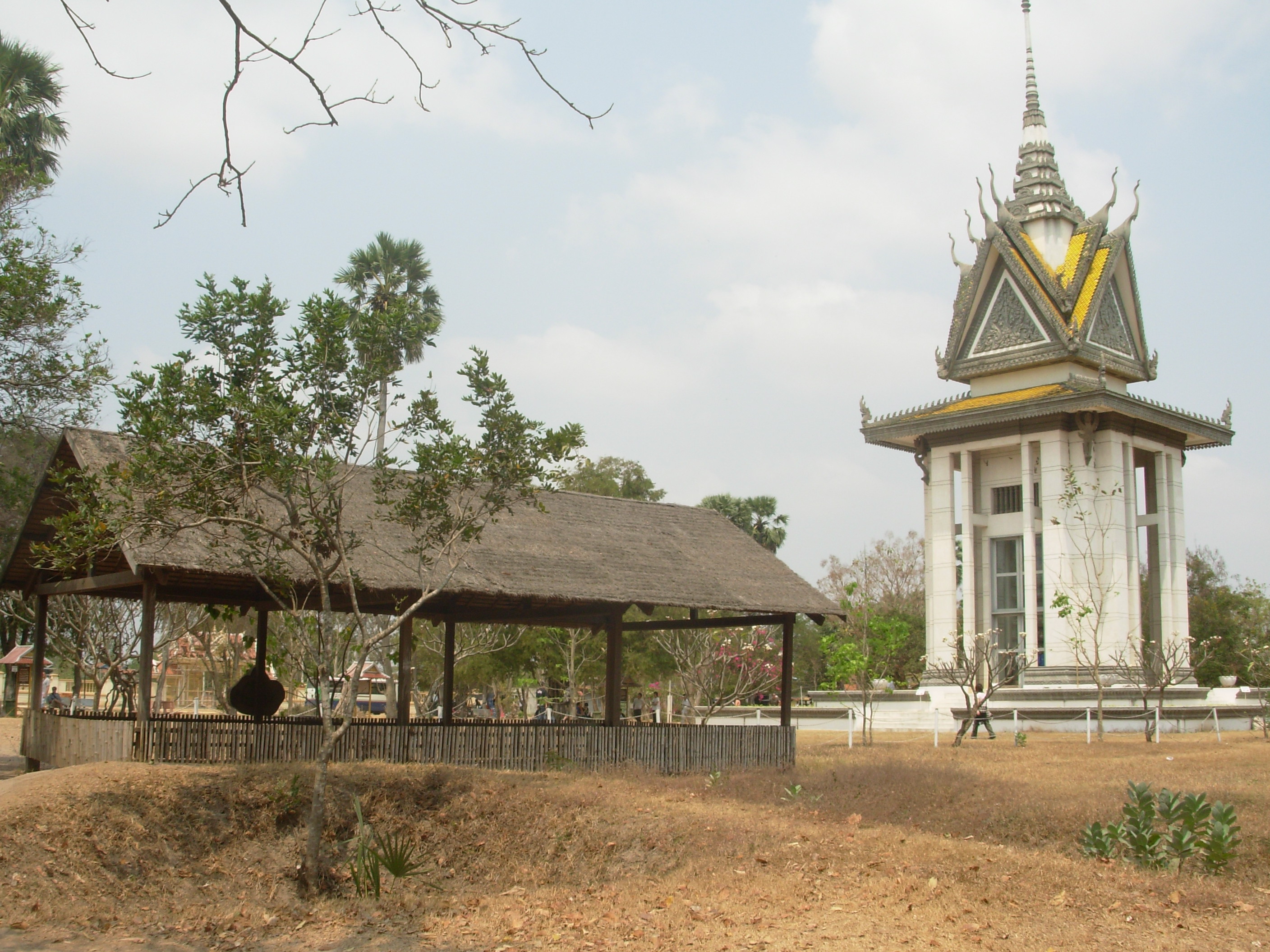 Les terribles "Killings Fields"de Choeung Ek et le stupa (à droite), qui contient les crânes de nombreuses victimes, classés selon la méthode d'exécution infligée par les Khmers rouges (cc by Jacques Beaulieu).