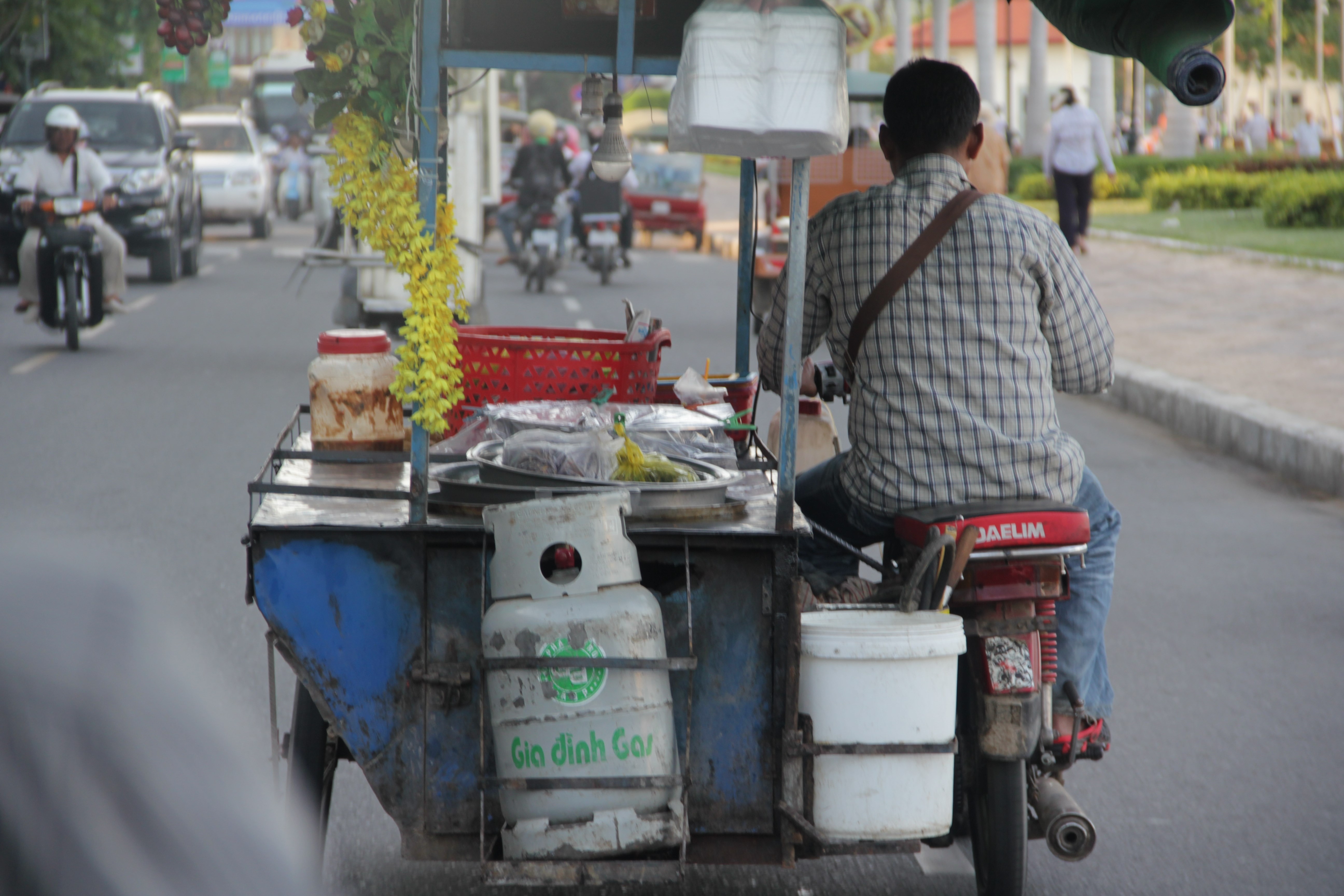 Beaucoup de marchands transportent la nourriture grâce à leur scooter (© Jérôme Decoster).