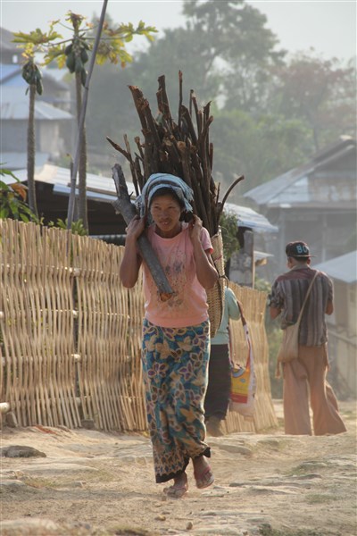 Dans le village de Tan Sent, les femmes portent des paniers en bambou chargés de bois (© Jérôme Decoster).