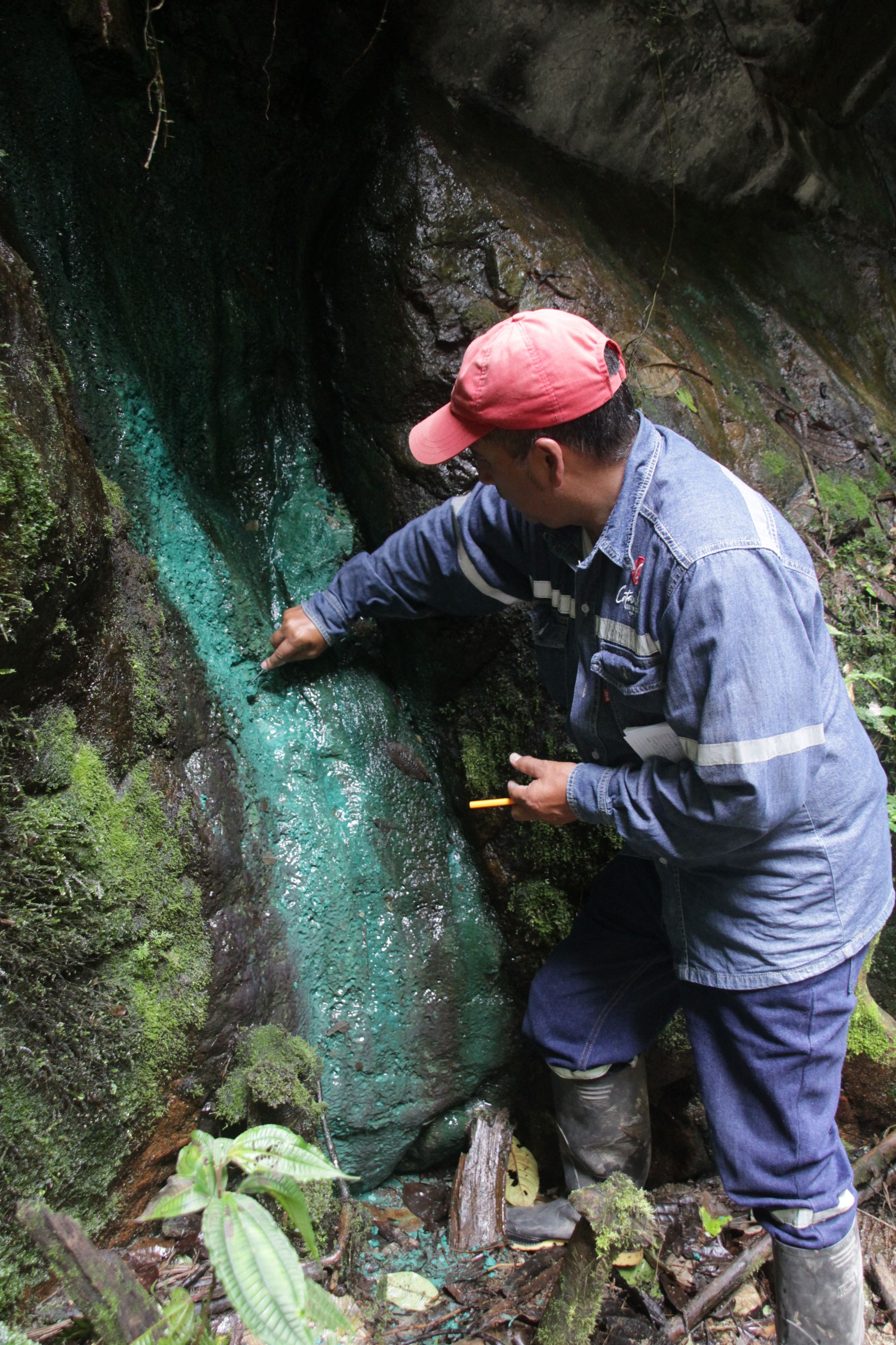 William, responsable du service des eaux de la municipalité de Cotacachi, prend un échantillon de cuivre sur la roche (© Jérôme Decoster).