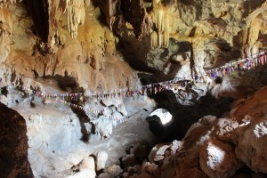 Comme plusieurs grottes, celle de Pha In sert de lieu de prière aux bouddhistes, qui l'ont ornée d'une guirlande de petits drapeaux (© Aurélie Bacheley).