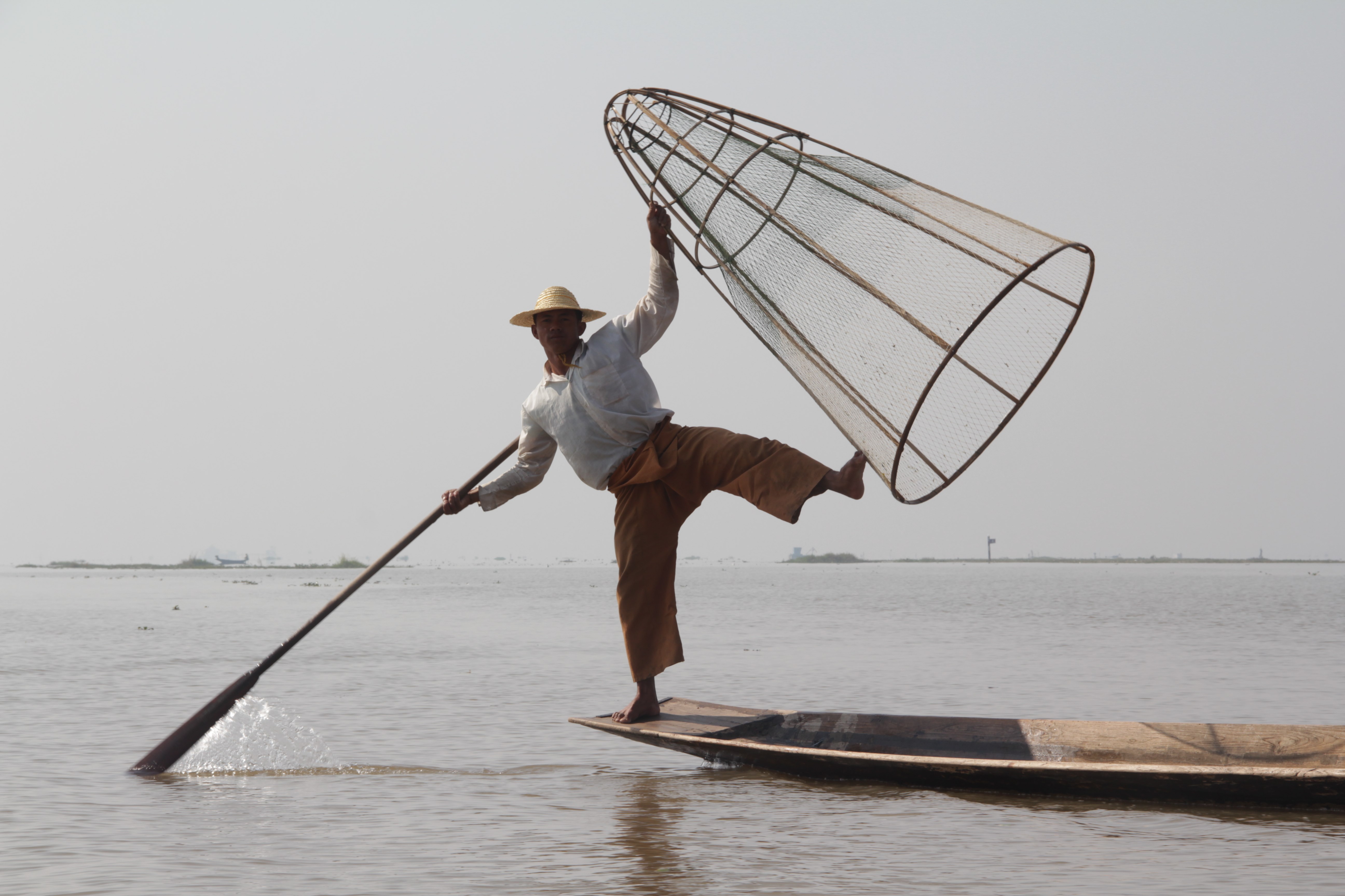 Pagaie au pied pour se diriger et filet à la main, les pêcheurs du lac Inle ont une allure de danseurs professionnels (© Jérôme Decoster).